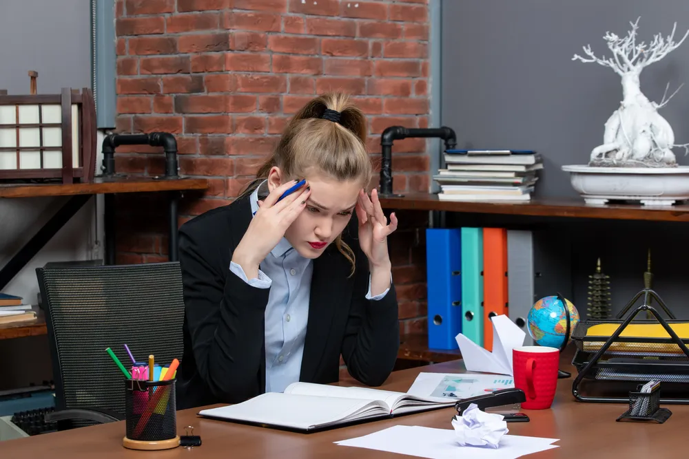 top-view-young-lady-sitting-table-focused-something-carefully-office