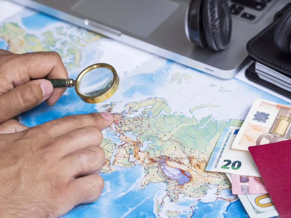 man-looking-map-with-magnifying-glass